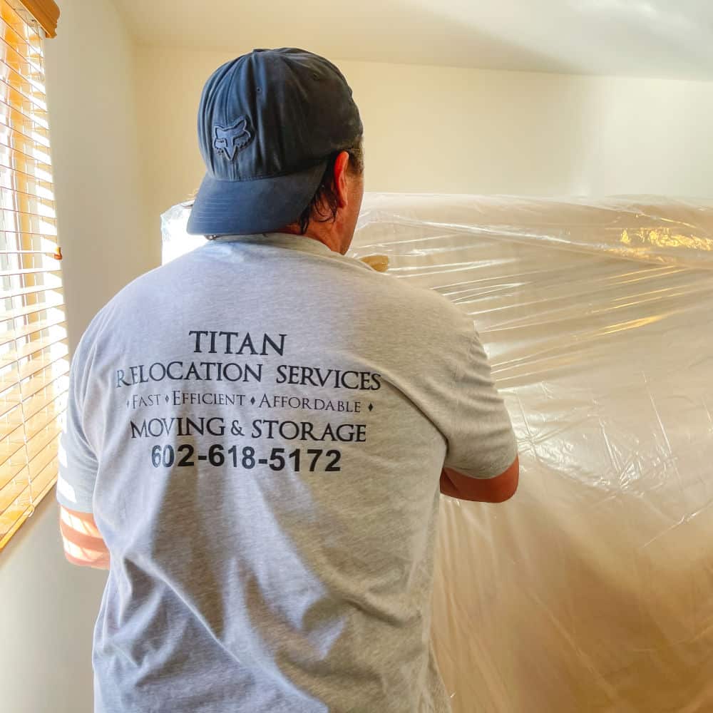 mover wrapping a mattress in protective plastic