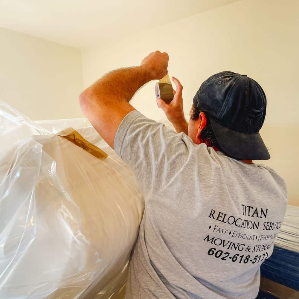 titan relocation services mover wrapping mattresses with plastic wrap